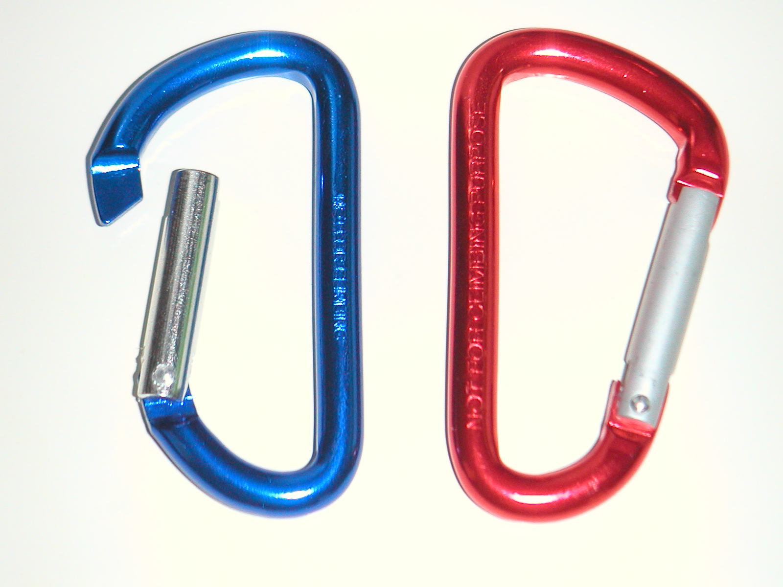 Real photograph of red and blue utility clips retaining NOT FOR CLIMBING markings; the left gate is held open. Visible parts only, not evidence of alloy, temper, coating or load capacity. Not JKPD products. Source brightness adjustment retained; unmodified here.