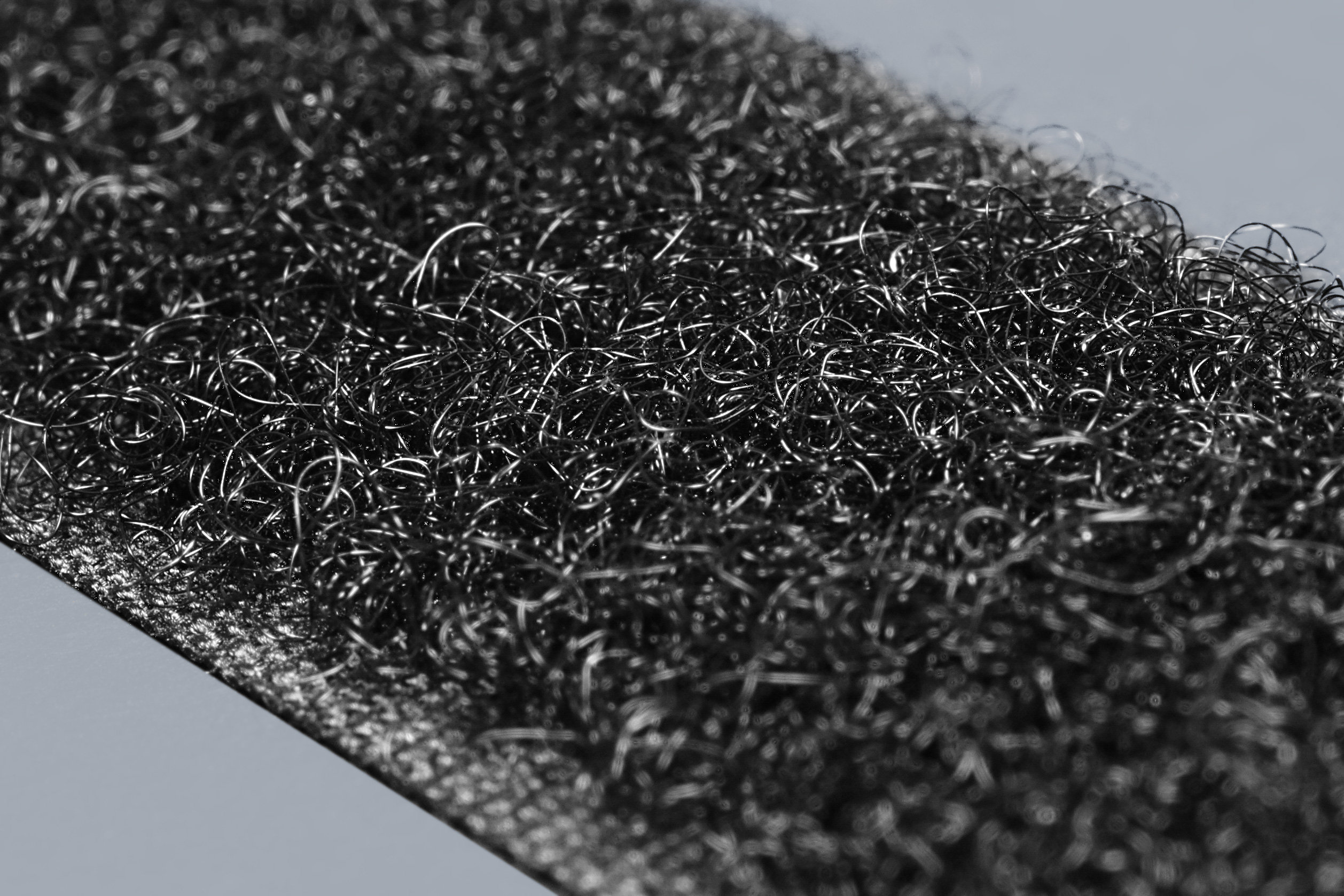 Real macro photograph of fine loops. Visible form only; composition, textile construction, brand and a matched article relationship to the hook photograph are unverified. Not a JKPD product.